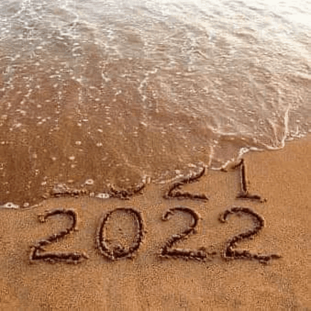 the word 2022 is written in the sand on the beach .
