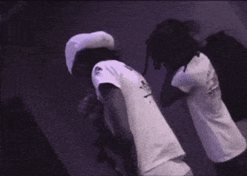a man in a white shirt with a skull on it stands next to another man