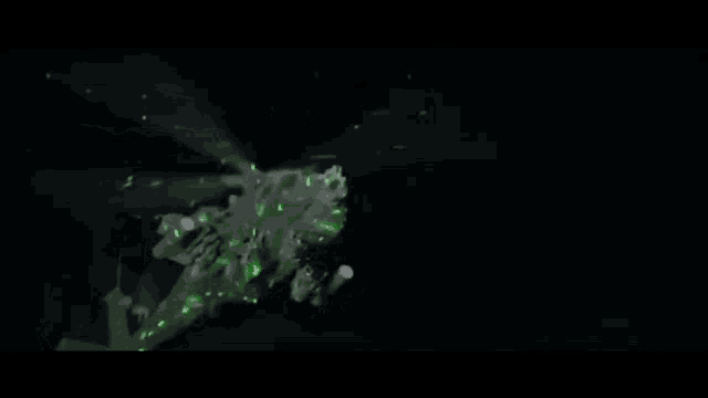 a helicopter is flying in the dark with green lights coming out of it 's tail .
