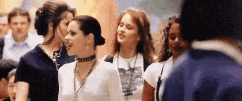 a group of women standing next to each other in a crowd .