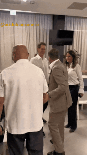 a group of people are standing in a room with the name acidobianconero on the bottom