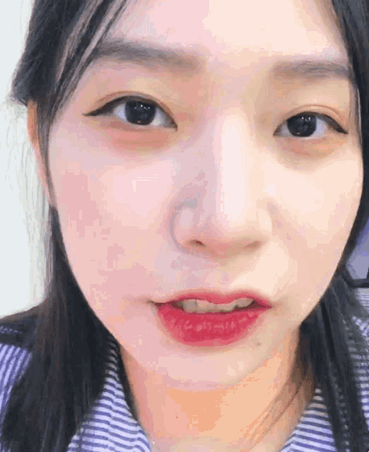 a close up of a woman 's face with red lipstick