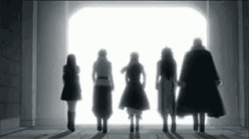 a group of people are standing in front of a light in a tunnel .