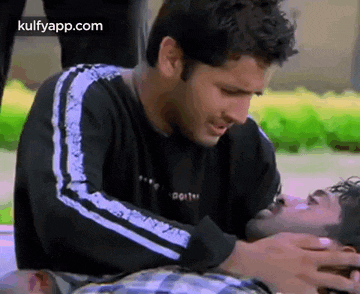 a man is putting his hand on another man 's chest while another man looks on .