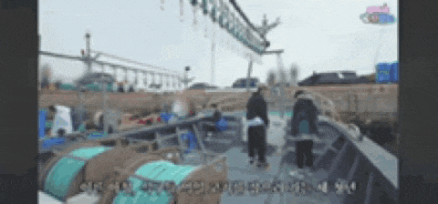 a group of people are standing on a boat with chinese writing on it