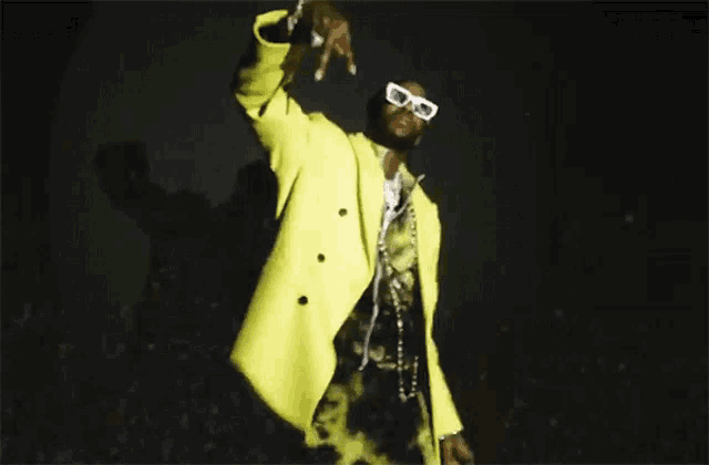 a man wearing sunglasses and a yellow coat