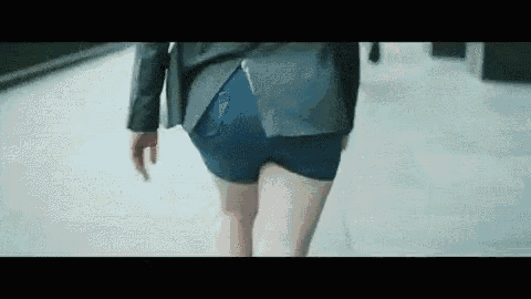 a woman is walking down the street wearing shorts and a jacket .