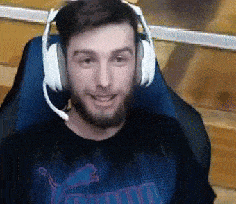 a man with a beard wearing headphones and a microphone is sitting in a chair .
