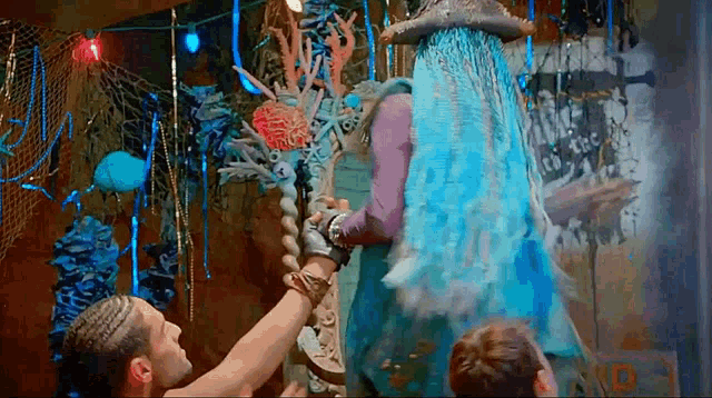 a man in a pirate hat is holding a statue of a mermaid in a room .