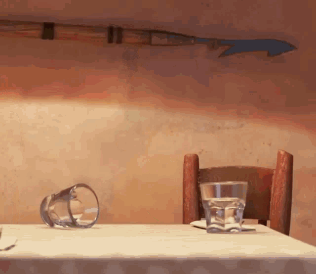 a table with two glasses on it and a chair
