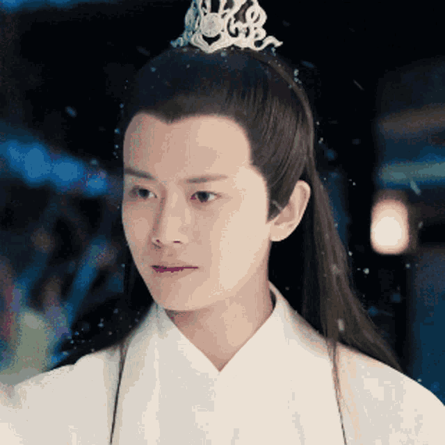 a man with a tiara on his head looks at the camera