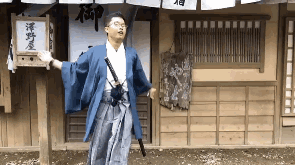 a man holding a sword in front of a building with chinese writing