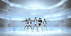 a group of people are dancing in a room with a blue background .