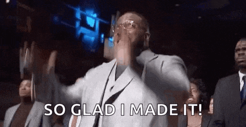 a man in a suit and tie is standing in front of a crowd and saying `` so glad i made it '' .