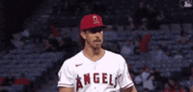 a baseball player wearing a white jersey with the word angels on it .