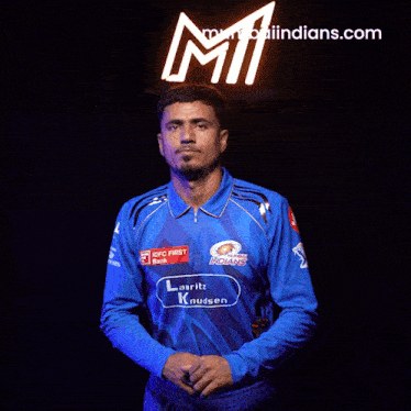 a man wearing a blue indians jersey holds his fist in the air