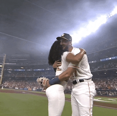 a baseball player with the number 11 on his jersey is hugging a woman