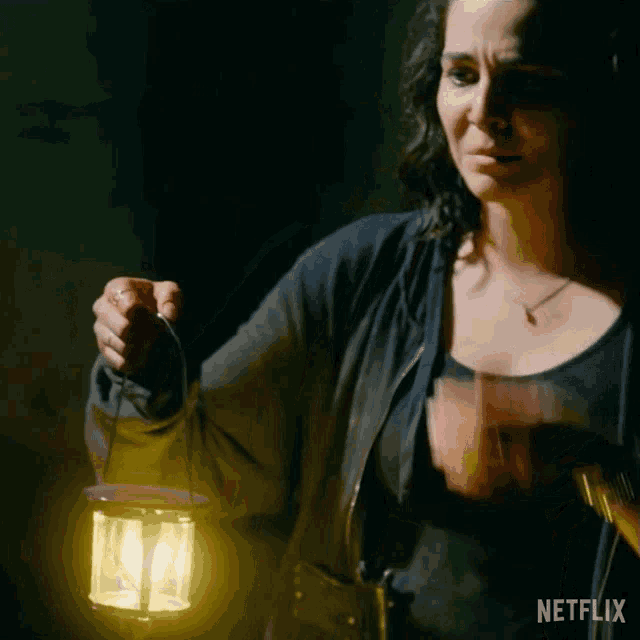 a woman is holding a lantern with netflix written on the bottom