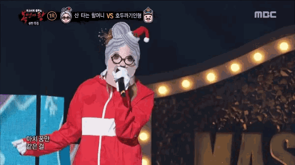 a person wearing a santa hat and glasses holds a microphone in front of a mbc logo