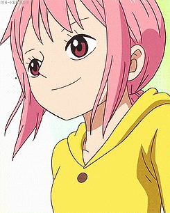 a girl with pink hair and a yellow shirt is smiling