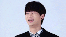 a young man wearing a black jacket and striped shirt is laughing