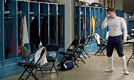 a man standing in a locker room with a sign that says uc