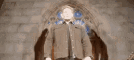 a man is standing in front of a stained glass window in a church .