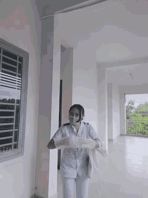 a woman wearing a mask and a name tag is holding a bag