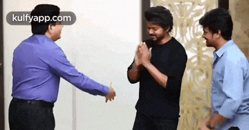 a group of men are standing next to each other in a room and shaking hands .