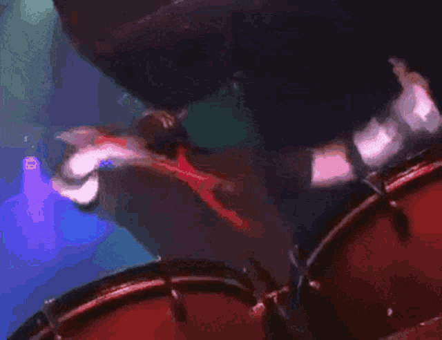 a man wearing a skull mask is holding a microphone and a drum