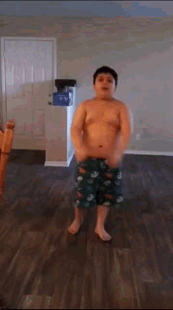 a man without a shirt is jumping in a living room