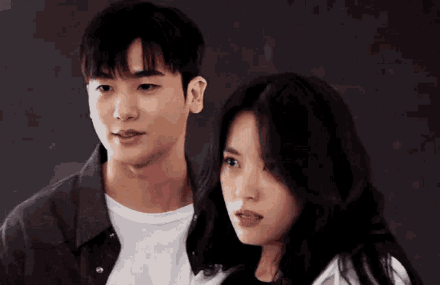 a man and a woman are standing next to each other looking at each other .