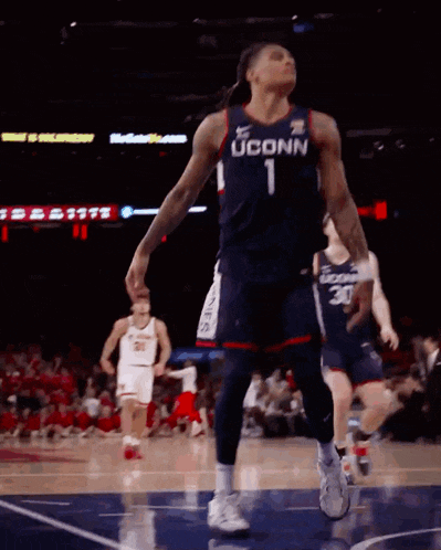 a uconn basketball player is jumping in the air during a game