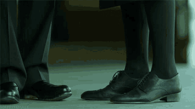 a man and a woman standing next to each other with their feet touching