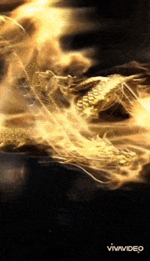 a gold dragon is surrounded by flames and smoke .