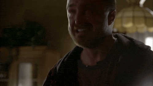 a man with a beard is smiling and looking at the camera