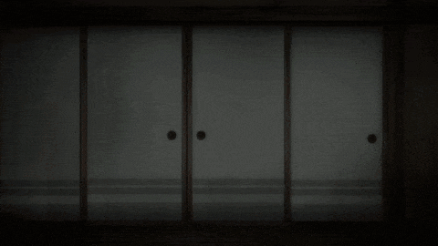 a man is running in a dark room with sliding doors behind him