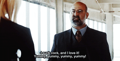 a man in a suit and tie is saying i suck cock and i love it