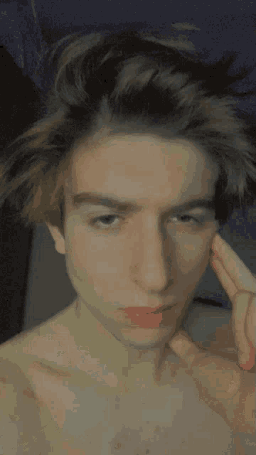 a close up of a young man 's face with a hand on his face