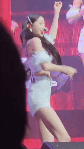 a woman in a light blue dress is dancing on a stage .
