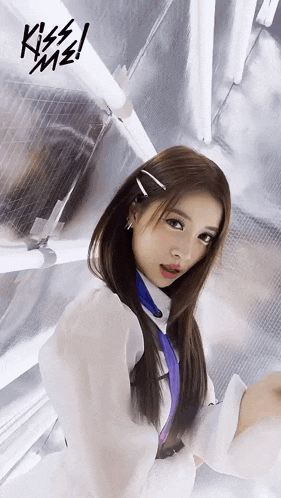 a girl in a white shirt with a purple tie stands in front of a wall with the word kiss on it