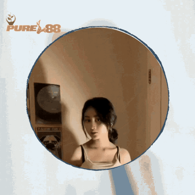 a woman is taking a picture of herself in a round mirror with a pure88 logo in the background