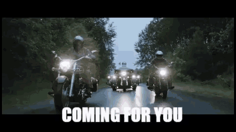 a group of motorcycle riders are riding down a country road in the rain .