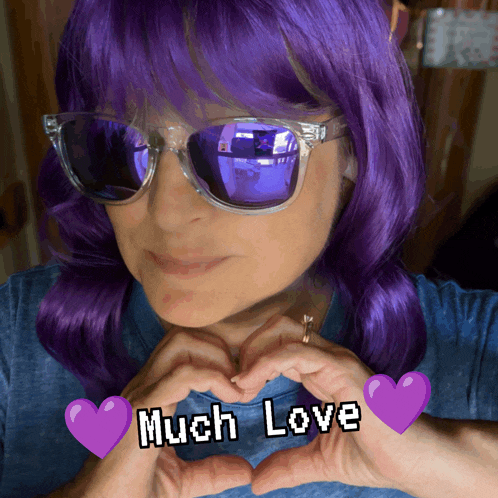 a woman with purple hair making a heart with her hands and the words much love
