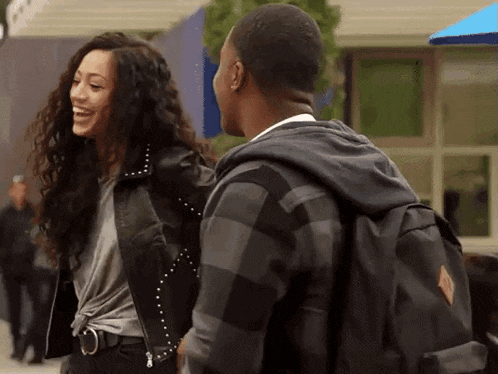 a man and a woman are standing next to each other laughing