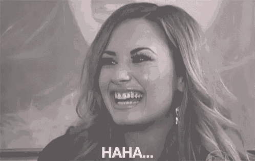 a woman is smiling and laughing in a black and white photo with the words `` haha '' written below her .