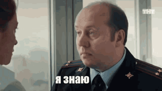a man in a military uniform is talking to a woman in a window .
