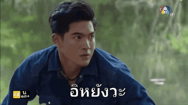 a man in a blue shirt with a foreign language written on the bottom of his shirt