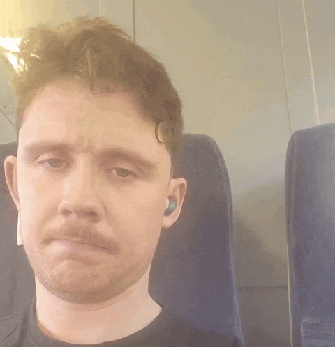 a man is making a funny face while sitting in a blue chair