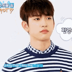a young man wearing a striped shirt and a plaid shirt is talking